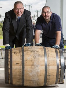 Former Benromach stillman Tom Anderson (L) and Brian Williams roll the first cask of whisky into Benromach's new warehouse August 8, 2014. Image courtesy Gordon & MacPhail. 