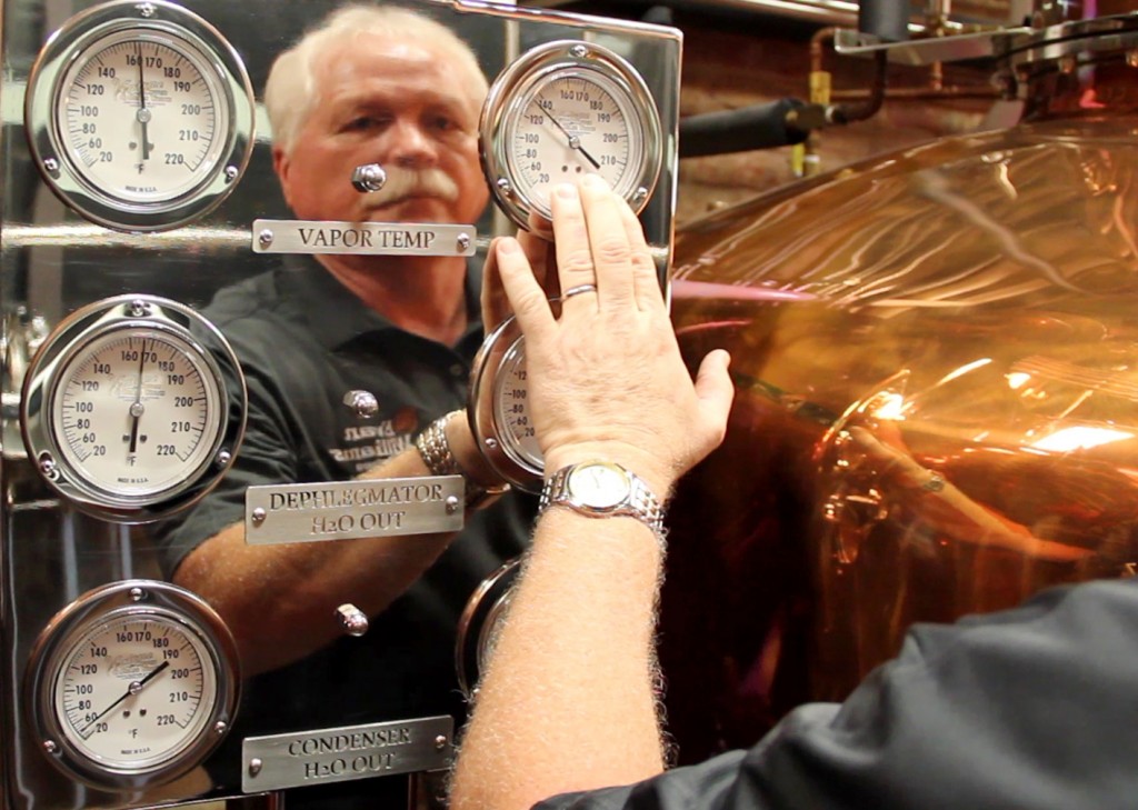Charlie Downs of the Evan Williams Bourbon Experience reflected in his stillroom's instrument panel September 16, 2014. Photo ©2014 by Mark Gillespie.