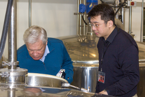 Dr. Jim Swan (L) and King Car Master Blender Ian Chang examine a fermenter in this file photo from March 29, 2011. Photo ©2011 by Mark Gillespie.