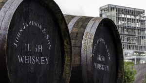 Whiskey barrels at Ireland's Midleton Distillery with the distillery in the background. Photo ©2013, Mark Gillespie/CaskStrength Media.