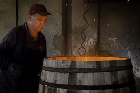 A cooper examines a barrel being toasted at the A. Páez Toneleria in Jerez de la Frontera, Spain. Photo ©2016, Mark Gillespie, CaskStrength Media. 