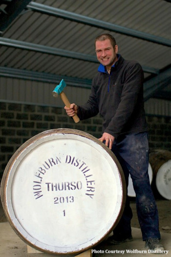 Wolfburn Distillery Production Manager Shane Fraser hammers the bung into the distillery's first barrel of new make spirit , January 2013.