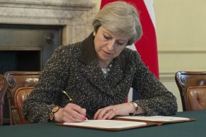 British Prime Minister Theresa May signs the letter invoking Article 50 of the Lisbon Treaty. Image courtesy HM Government Press Office.