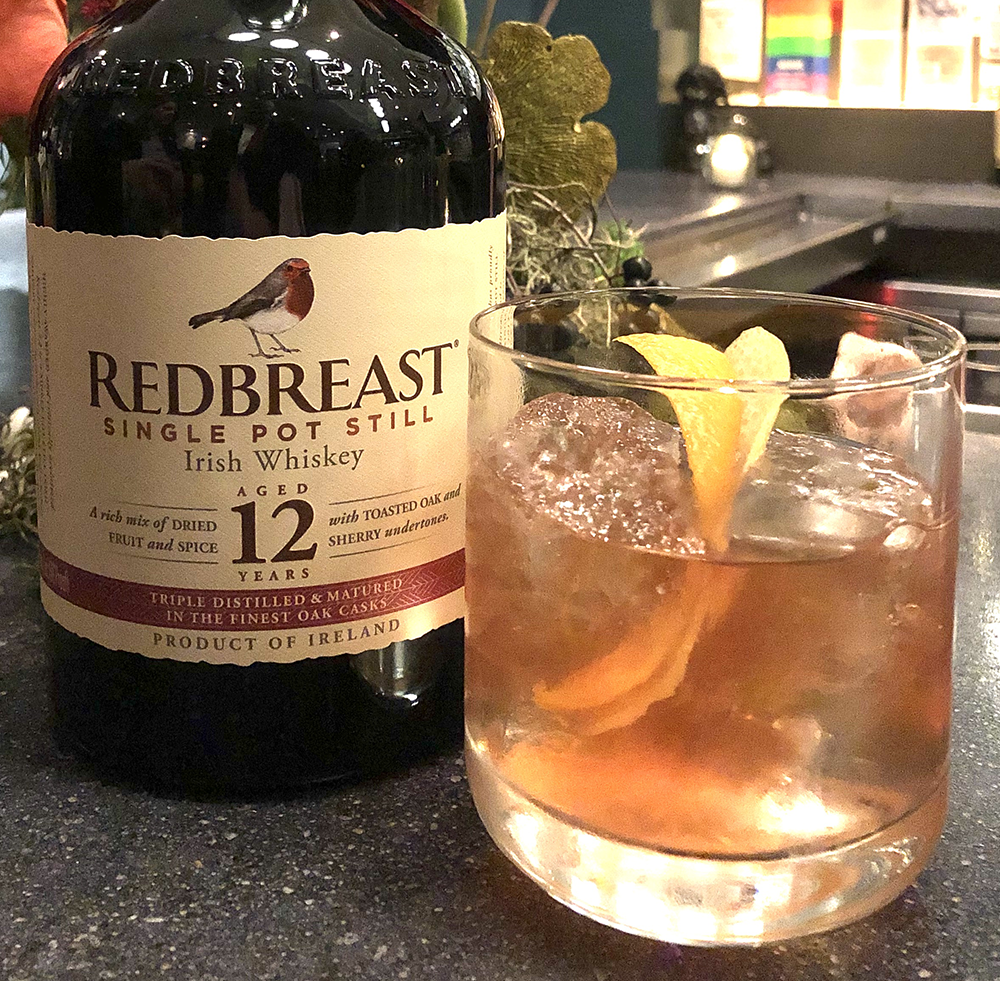 A bottle of Redbreast 12 Year Old next to a whiskey cocktail. Photo ©2019, Mark Gillespie/CaskStrength Media.