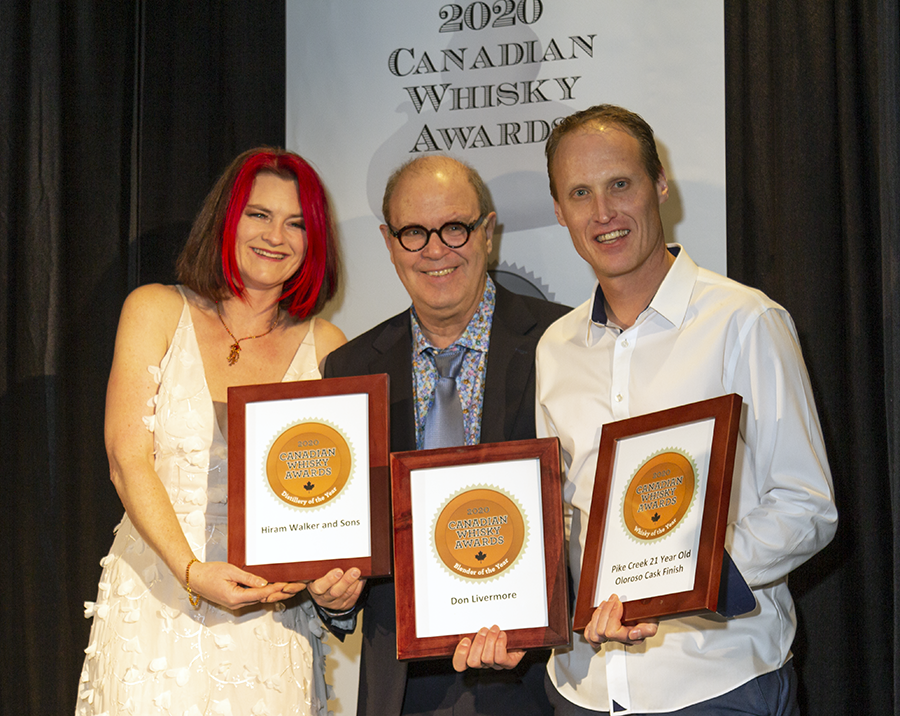 Hiram Walker Distillery took top hono(u)rs at the 2020 Canadian Whisky Awards presentation during the Victoria Whisky Festival. Presenter Heather Leary, Canadian Whisky Awards chairman Davin de Kerghommeaux, and Hiram Walker master blender Dr. Don Livermore showed off the awards for Canadian Whisky of the Year, Distillery of the Year, and Blender of the Year following the ceremony. Photo ©2020, Mark Gillespie/CaskStrength Media. Hiram Walker Distillery took top hono(u)rs at the 2020 Canadian Whisky Awards presentation during the Victoria Whisky Festival. Presenter Heather Leary, Canadian Whisky Awards chairman Davin de Kerghommeaux, and Hiram Walker master blender Dr. Don Livermore showed off the awards for Canadian Whisky of the Year, Distillery of the Year, and Blender of the Year following the ceremony. Photo ©2020, Mark Gillespie/CaskStrength Media.