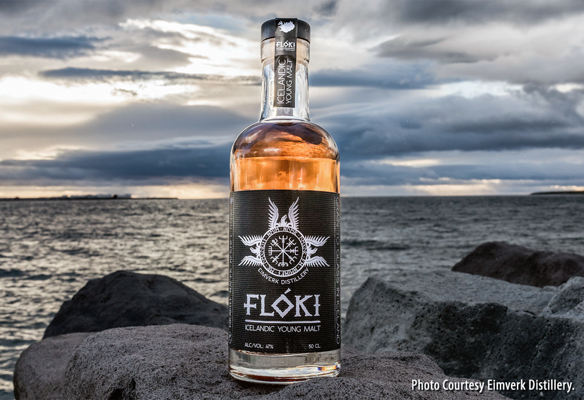A bottle of Flóki Icelandic Whisky on the beach. Image courtesy Eimverk Distillery.