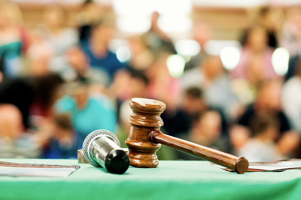 An auctioneer's gavel and microphone on the podium. Image courtesy Adobe Stock.