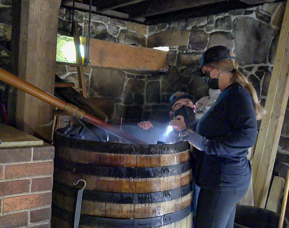 Tom and Kim Carter Bard look over spirit condensing off one of the stills at George Washington's Distillery at Mount Vernon. Photo ©2021, Mark Gillespie/CaskStrength Media.