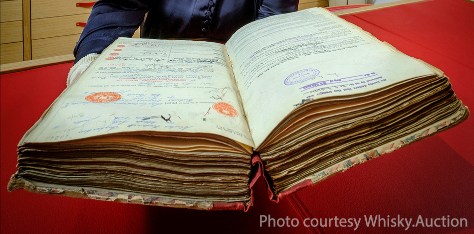 Diageo archive manager Christine McCaffrey holds a 1944 ledger of shares in John Walker & Sons. Photo courtesy Whisky.Auction.